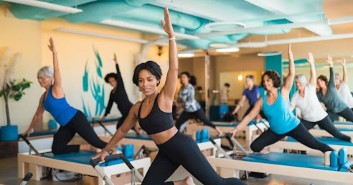 The image depicts a dynamic Pilates session in a modern studio, featuring a diverse group of individuals using reformer machines and mats, with a warm color palette highlighting the energetic and inclusive atmosphere, subtly infused with coastal elements reminiscent of Carlsbad, California.
